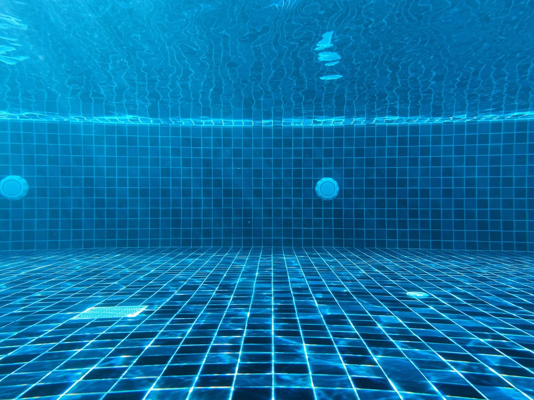 Blue tiled swimming pool surface related to poolside floor safety
